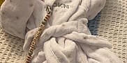 Archie joined the competition — help win amazing prizes! baby, blanket, booties, child, clothing, cozy, cute, indoor, infant, knitted_blanket, pacifier_clip, peaceful, person, resting, sleep, sleeping, soft, textured_background, white_robe, yellow_background