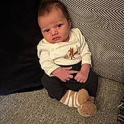 Archie joined the competition — help win amazing prizes! baby, infant, child, face, sitting, couch, pillow, pattern, clothing, socks, indoor, cute, young, person, portrait, expression, furniture, cozy, home, soft