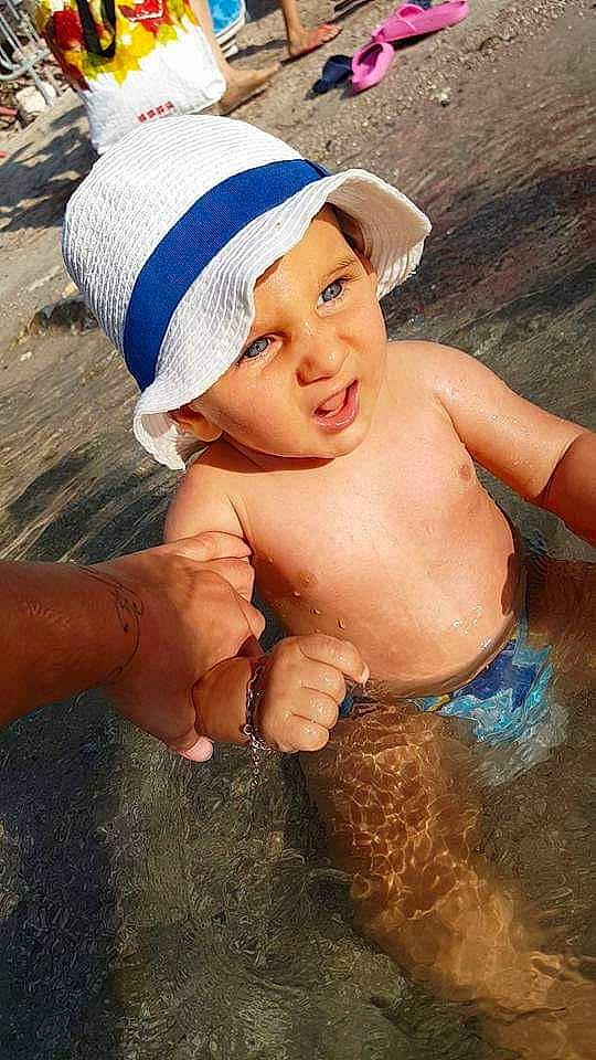 Julian participe au concours pour gagner de l'argent avec cette photo : barechestedness, boy, cap, cheek, child, eye, facial_expression, fun, girl, hand, happiness, headgear, headwear, human_hair_color, mouth, person, skin, smile, summer, toddler