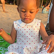 Kehlany participe au concours pour gagner de l'argent avec cette photo : toddler, child, beach, sitting, dress, red_bow, curly_hair, green_towel, sand, sunlight, outdoor, trees, palm_trees, people, summer, casual, daytime, cute, portrait, relaxing