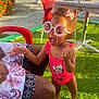 Kehlany participe au concours pour gagner de l'argent avec cette photo : toddler, child, sunglasses, pink_swimsuit, minnie_mouse, barefoot, grass, red_chair, adult, outdoor, sunny, table, tropical_plants, happy, laughing, hair_bow, vacation, beach, summer, playful
