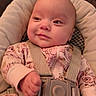 baby, infant, child, onesie, seatbelt, car_seat, cushion, face, head, hand, clothing, pattern, pink, safety, indoor, portrait, cute, young, person, expression