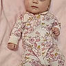 baby, infant, blanket, onesie, floral_pattern, sleepwear, face, head, hands, lying_down, soft_texture, pink, cute, child, portrait, newborn, calm, indoors, cozy, resting