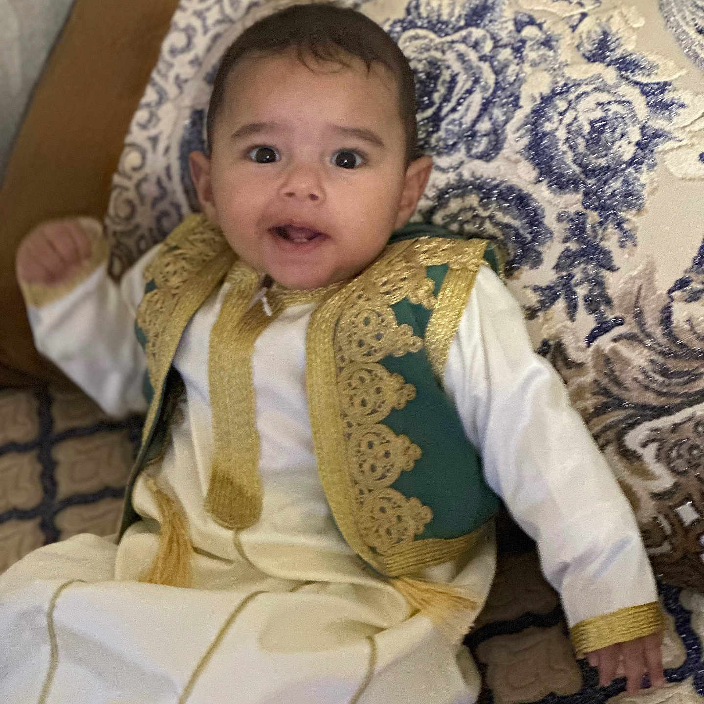 Mehdi a rejoint le concours — aidez-le/la à gagner de superbes lots ! baby, child, clothing, curious, cushion, cute, face, furniture, gold_embroidery, happy, head, indoors, patterned_fabric, person, portrait, sitting, smile, textile, traditional_clothing, young_child