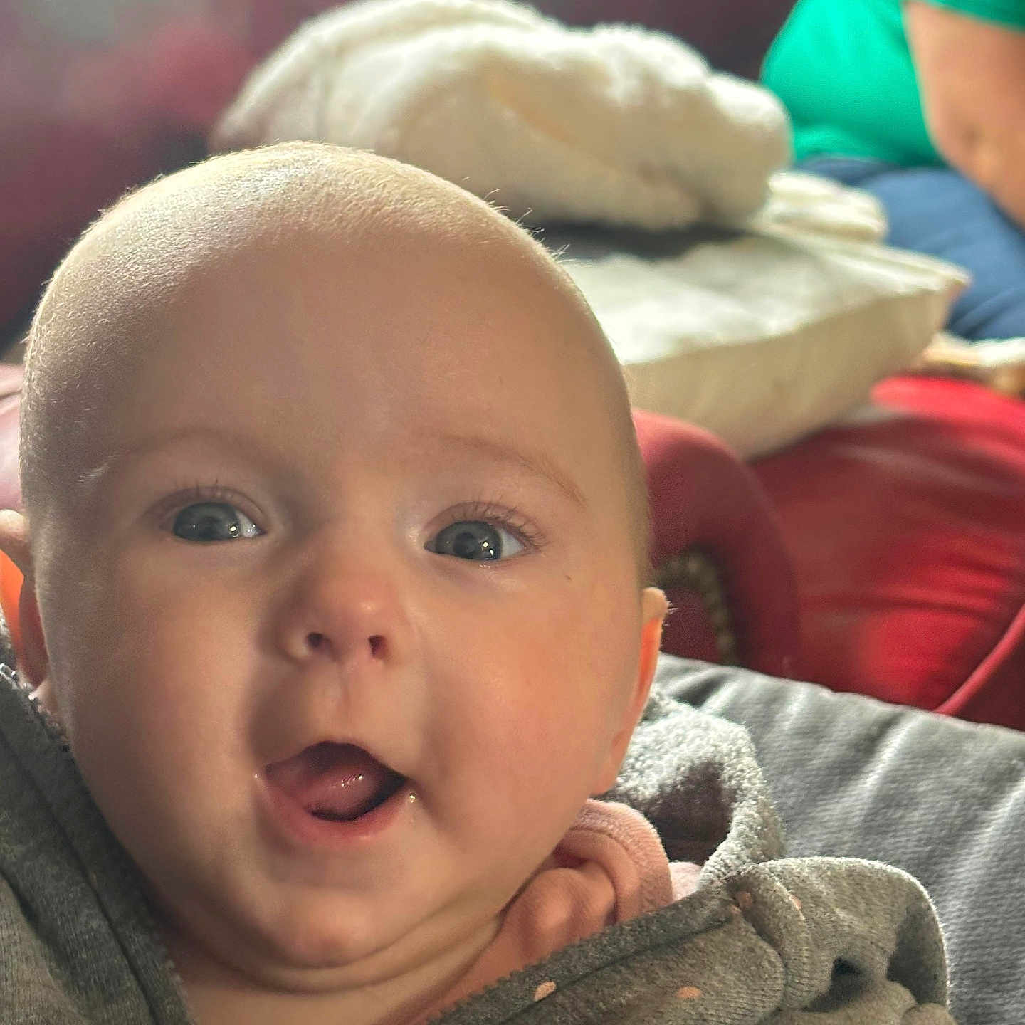 Sophia is registered to the contest to win money with this photo: baby, bodypart, clothing, coat, couch, cushion, face, furniture, happy, head, homedecor, jacket, knitwear, mouth, pants, person, photography, portrait, selfie, sweater