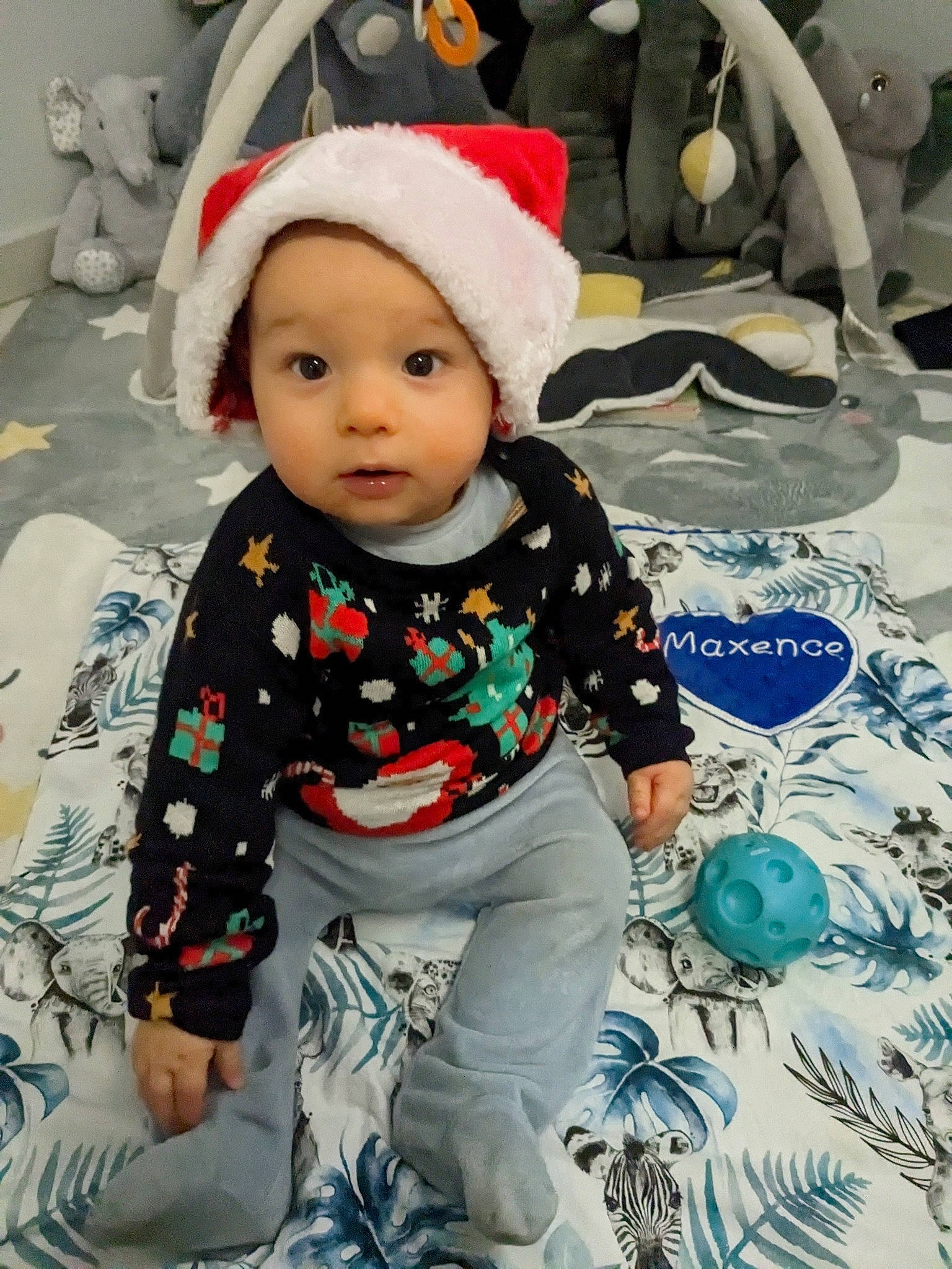 Maxence participe au concours pour gagner de l'argent avec cette photo : baby, baby_products, baby_toddler_clothing, beanie, cap, cheek, child, happy, headgear, headwear, knit_cap, linens, pattern, people, person, sitting, sleeve, t_shirt, textile, toddler
