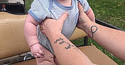Richard joined the competition — help win amazing prizes! baby, blue_eyes, child, cute, daylight, expression, foot, golf_cart, grass, hands, holding, infant, nature, outdoor, person, seat, striped_clothing, summer, tattoos, trees
