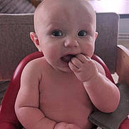 Richard joined the competition — help win amazing prizes! baby, child, high_chair, indoor, curious, chewing, fingers, skin, arm, face, wide_eyes, window, natural_light, wooden_sign, background, person, seated, red, cozy, home