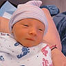 Buckley is registered to the contest to win money with this photo: newborn, baby, blanket, footprint_pattern, hat, striped_hat, person, hand, indoor, resting, sleepy, wrapped, hospital, cozy, infant, skin, cute, peaceful, portrait, closeup