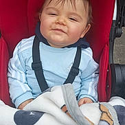 Hugo participe au concours pour gagner de l'argent avec cette photo : baby, child, stroller, blanket, red, blue_sweatshirt, smile, face, person, clothing, outdoor, happy, hoodie, baby_seat, cozy, infant, cute, bundle, casual, comfort