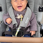 Louis a rejoint le concours — aidez-le/la à gagner de superbes lots ! baby, stroller, smiling, sweater, pacifier, clip, seatbelt, child, happy, person, clothing, fabric, footwear, sitting, outdoor, pale_skin, head, hand, toy, comfort