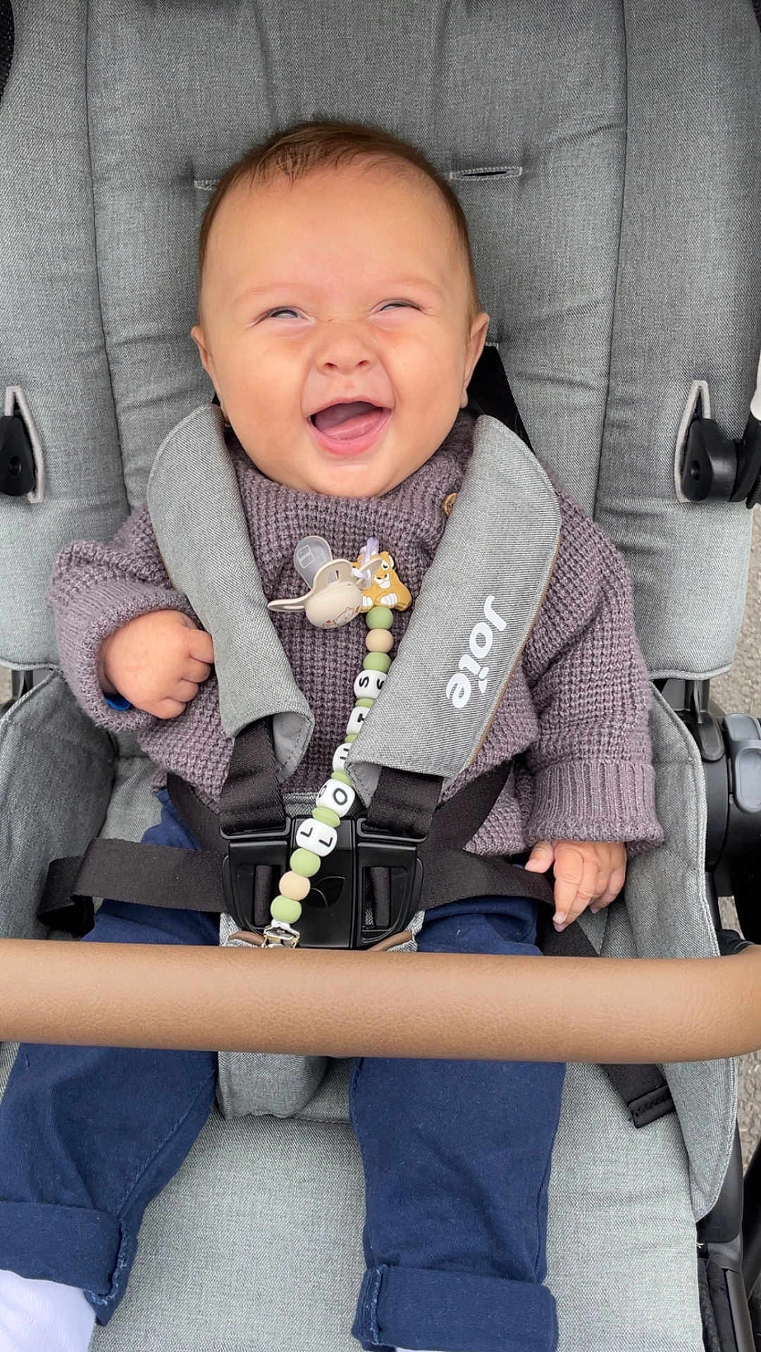 Louis a rejoint le concours — aidez-le/la à gagner de superbes lots ! baby, stroller, smiling, sweater, pacifier, clip, seatbelt, child, happy, person, clothing, fabric, footwear, sitting, outdoor, pale_skin, head, hand, toy, comfort