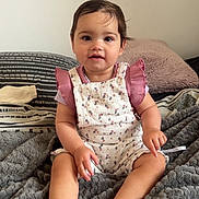 Summer participe au concours pour gagner de l'argent avec cette photo : baby, bed, blanket, child, clothing, cozy, cute, feet, floral, hand, heart, indoors, infant, person, pink, portrait, romper, sitting, smiling, soft