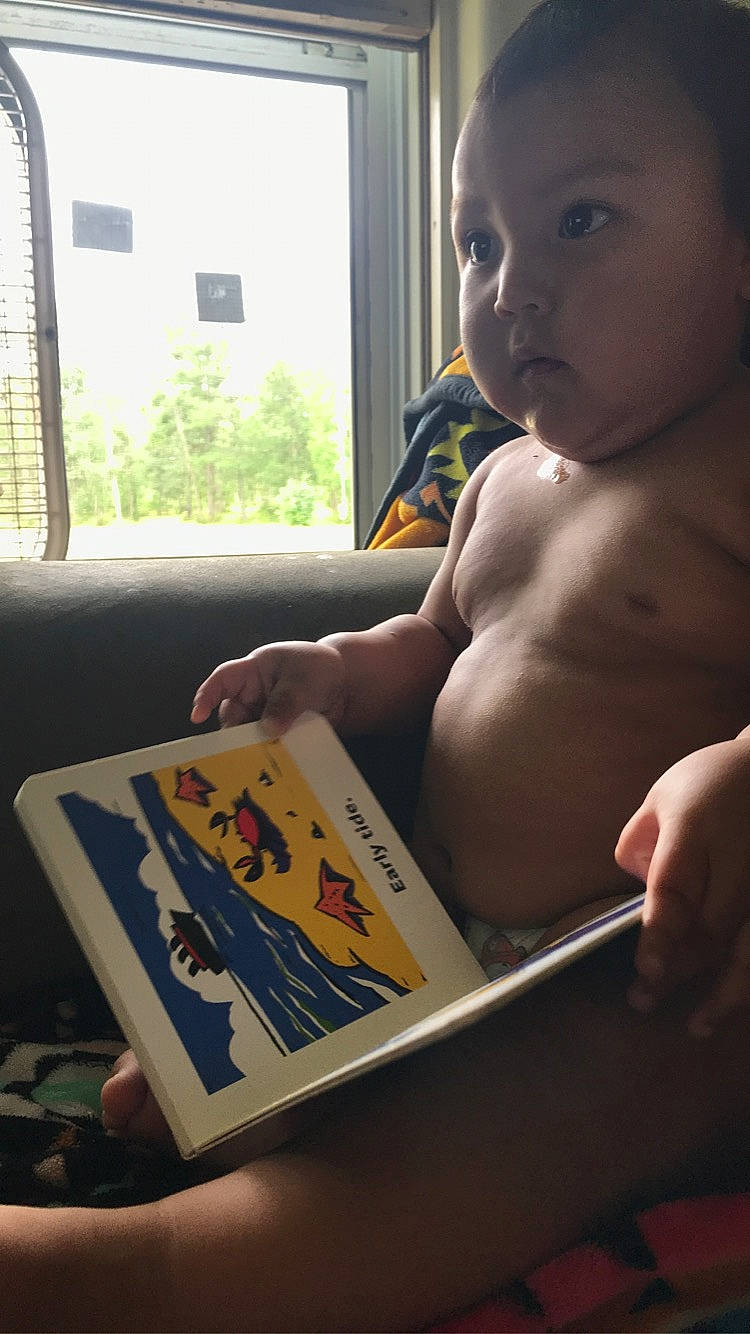 Tavion is registered to the contest to win money with this photo: baby, chest, child, elbow, finger, fun, gadget, laptop, mammal, nail, nose, person, personal_computer, reading, recreation, thumb, toddler, tree, trunk, vacation