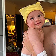 Keanu joined the competition — help win amazing prizes! baby, infant, smile, yellow_hat, diaper, white_sock, arm, hand, mirror, room, clutter, box, huggies, reflection, indoor, person, holding, cute, happy, child