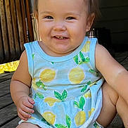 Kalina is registered to the contest to win money with this photo: baby, child, smile, sitting, dress, lemon_pattern, wooden_floor, happy, cute, toddler, face, skin, arm, leg, daylight, outdoor, infant, person, clothing, nature