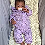 baby, pacifier, purple_clothing, floral_pattern, blanket, soft_texture, infant, lying_down, bracelet, cute_outfit, baby_clothes, indoor, comfortable, small_feet, child, newborn, portrait, resting, baby_bedding, calm