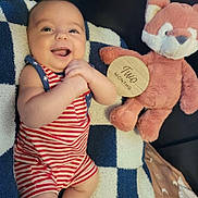 Kenton joined the competition — help win amazing prizes! baby, infant, smiling, striped_clothing, plush_toy, stuffed_animal, fox, blanket, wooden_sign, happy, clapping, cute, indoors, child, two_months, face, hands, soft_toy, lying_down, portrait