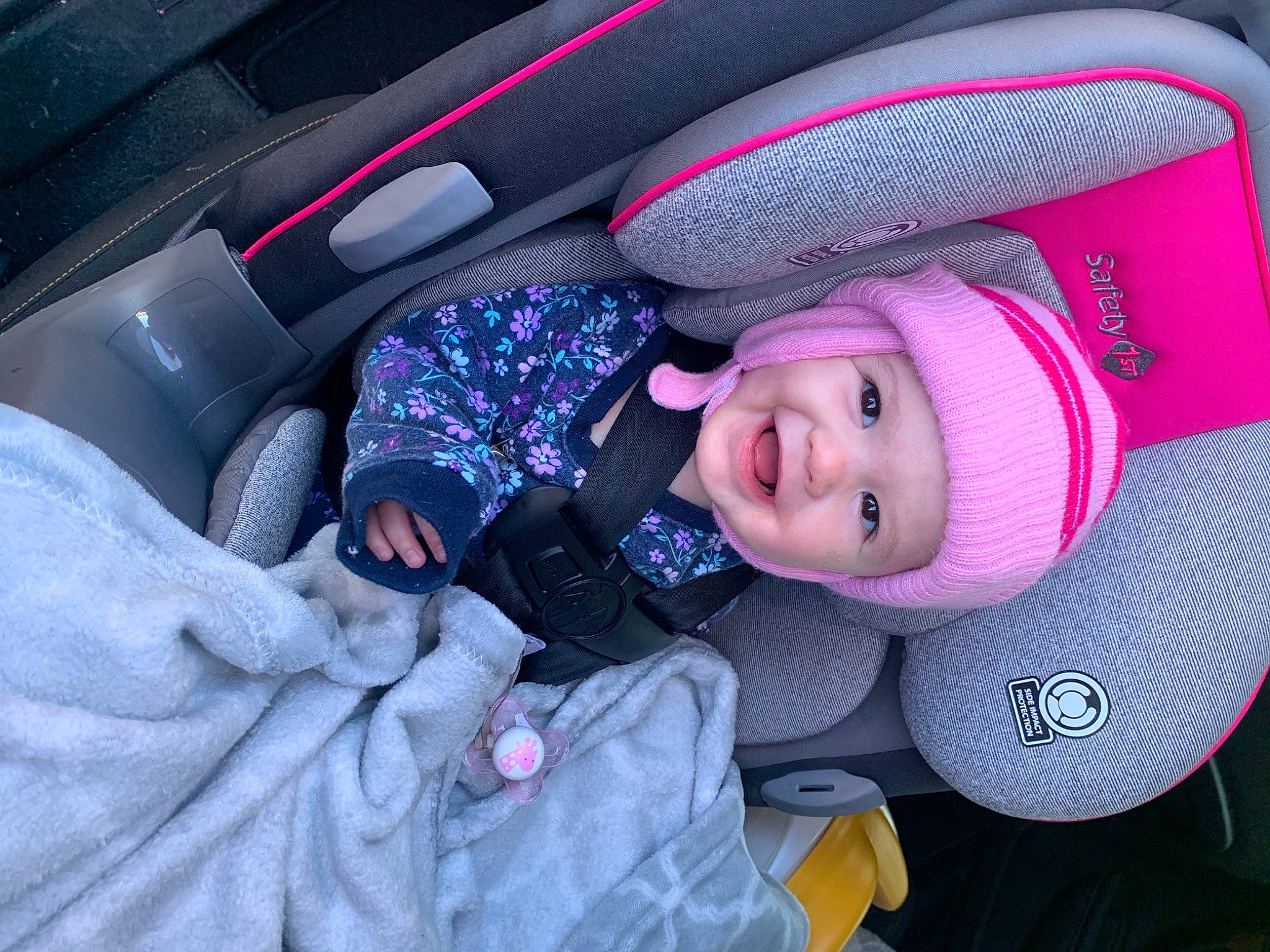 Marilynn is registered to the contest to win money with this photo: auto_part, automotive_design, baby, baby_carriage, cap, car, car_seat, car_seat_cover, comfort, electric_blue, finger, hat, headgear, headwear, human_body, person, purple, smile, toddler, vehicle_door