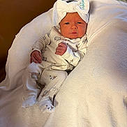 Oaklee is registered to the contest to win money with this photo: baby, newborn, infant, blanket, headband, bow, white_clothing, onesie, cute, sleeping_area, indoors, soft_texture, resting, small_hands, baby_fashion, portrait, child, cozy, comfortable, face