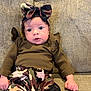 Oaklee is registered to the contest to win money with this photo: baby, infant, child, camo_bow, camo_pants, brown_shirt, couch, texture, wide_eyes, curious, clothing, fist, portrait, indoor, sitting, headband, cute, young, person, fabric