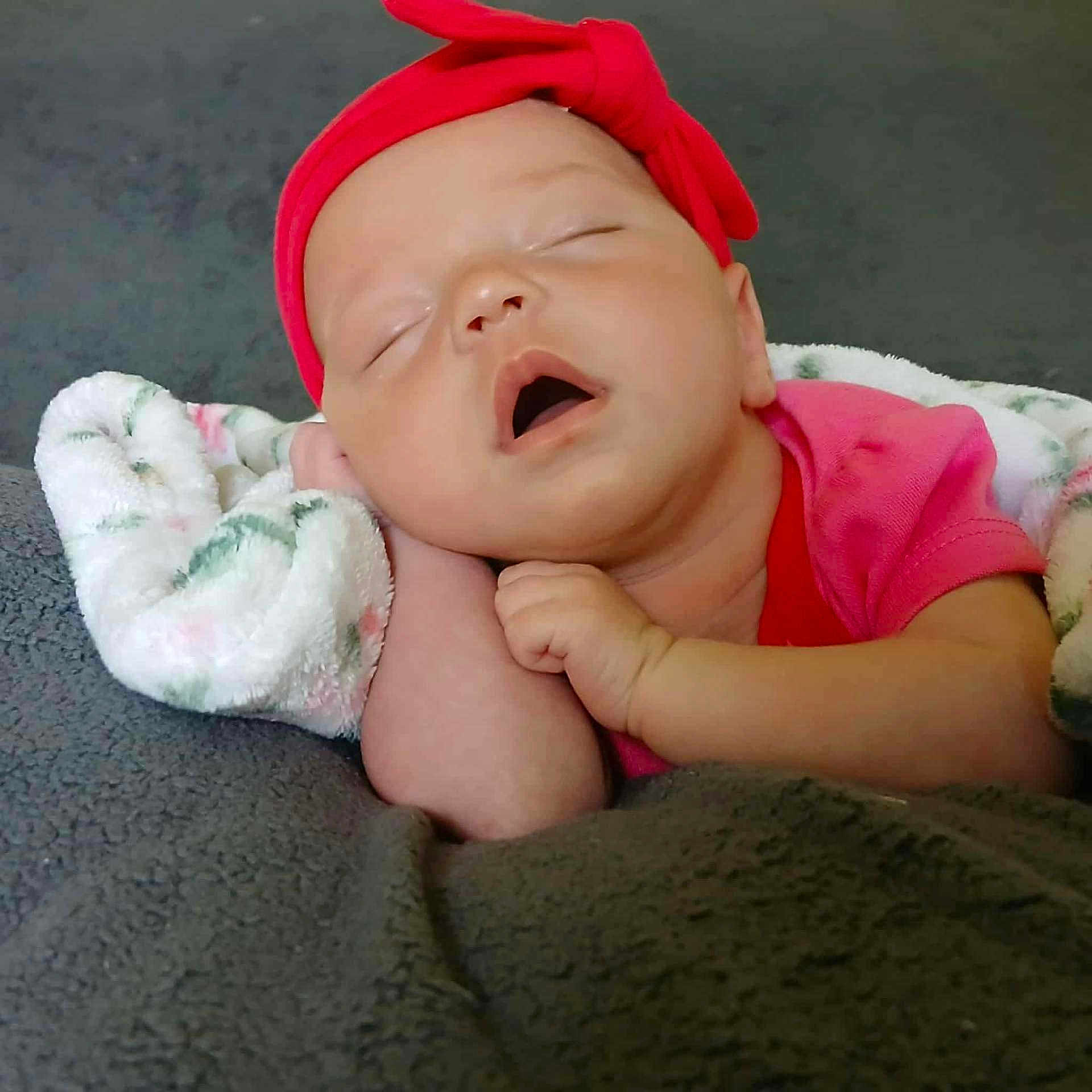 Raven is registered to the contest to win money with this photo: baby, blanket, child, closeup, comfort, cozy, cute, face, hand, headband, indoors, infant, peaceful, pink_clothing, portrait, resting, sleep, sleeping, soft_texture, young_child