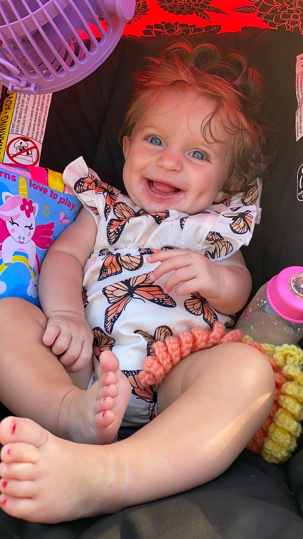 Novah is registered to the contest to win money with this photo: arm, baby, baby_products, baby_toddler_clothing, cheek, child, face, finger, fun, happy, joy, lap, leg, pattern, person, pink, sitting, skin, smile, sock