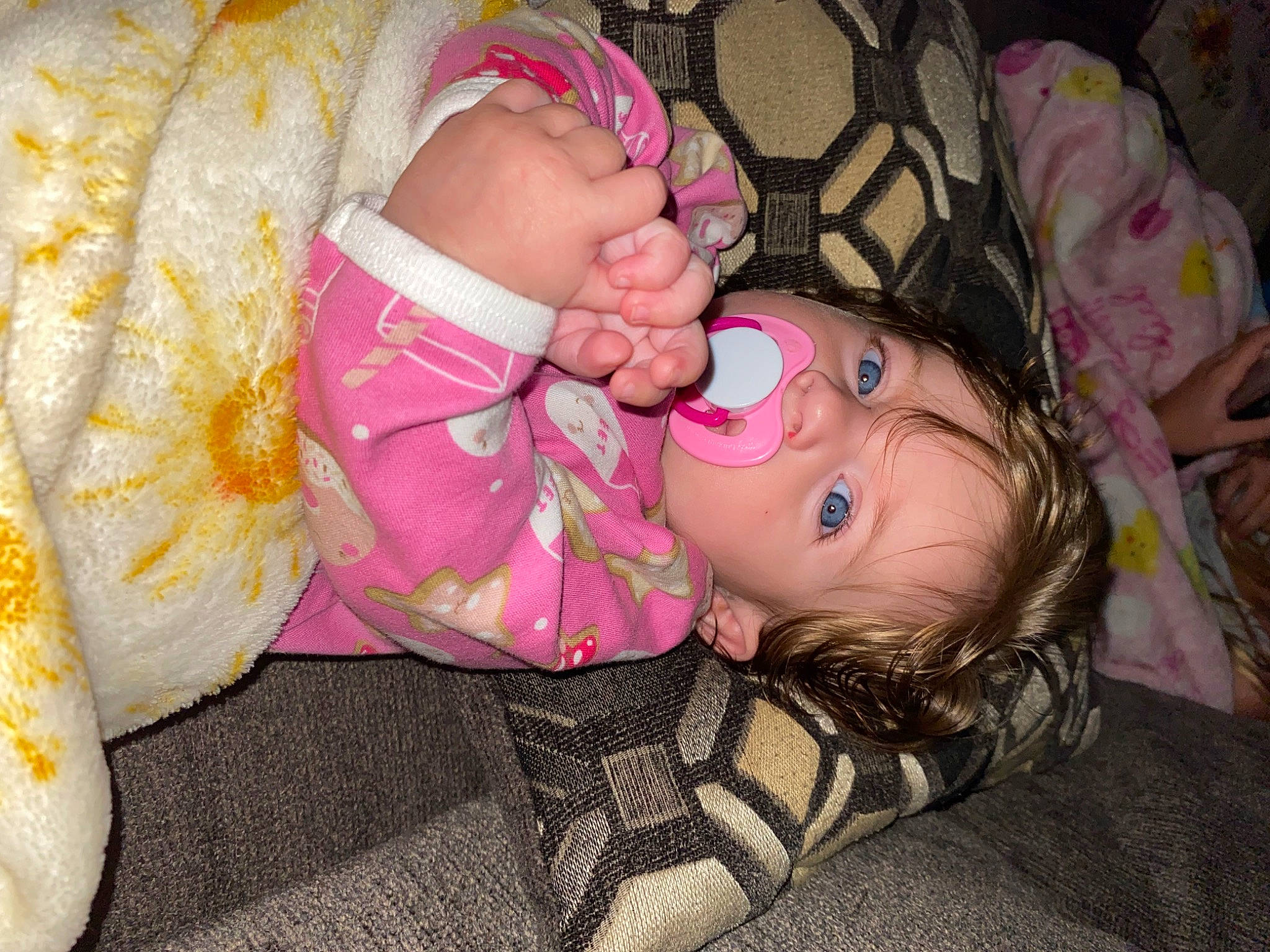 Novah is registered to the contest to win money with this photo: baby, baby_products, baby_toddler_clothing, cheek, child, comfort, eye, finger, fun, happy, head, human_body, nail, pattern, person, pink, room, sitting, skin, thigh