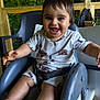 toddler, child, smiling, high_chair, outdoor, greenery, wooden_deck, baby_clothes, happy, cute, arms_outstretched, face, feet, seatbelt, plastic_chair, wood, nature, playful, infant, portrait