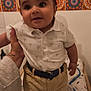 Zakaria participe au concours pour gagner de l'argent avec cette photo : baby, child, polo_shirt, shorts, belt, hand, blanket, tiles, patterned_wall, indoor, smiling, cute, standing, person, infant, clothing, portrait, wall_decor, soft_light, happy