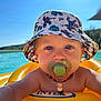 Milo participe au concours pour gagner de l'argent avec cette photo : baby, child, pacifier, bucket_hat, marvel_comics, pool, inflatable_ring, sunny, blue_sky, water, outdoor, summer, swimming, floating, necklace, closeup, infant, young_child, toy, relaxation