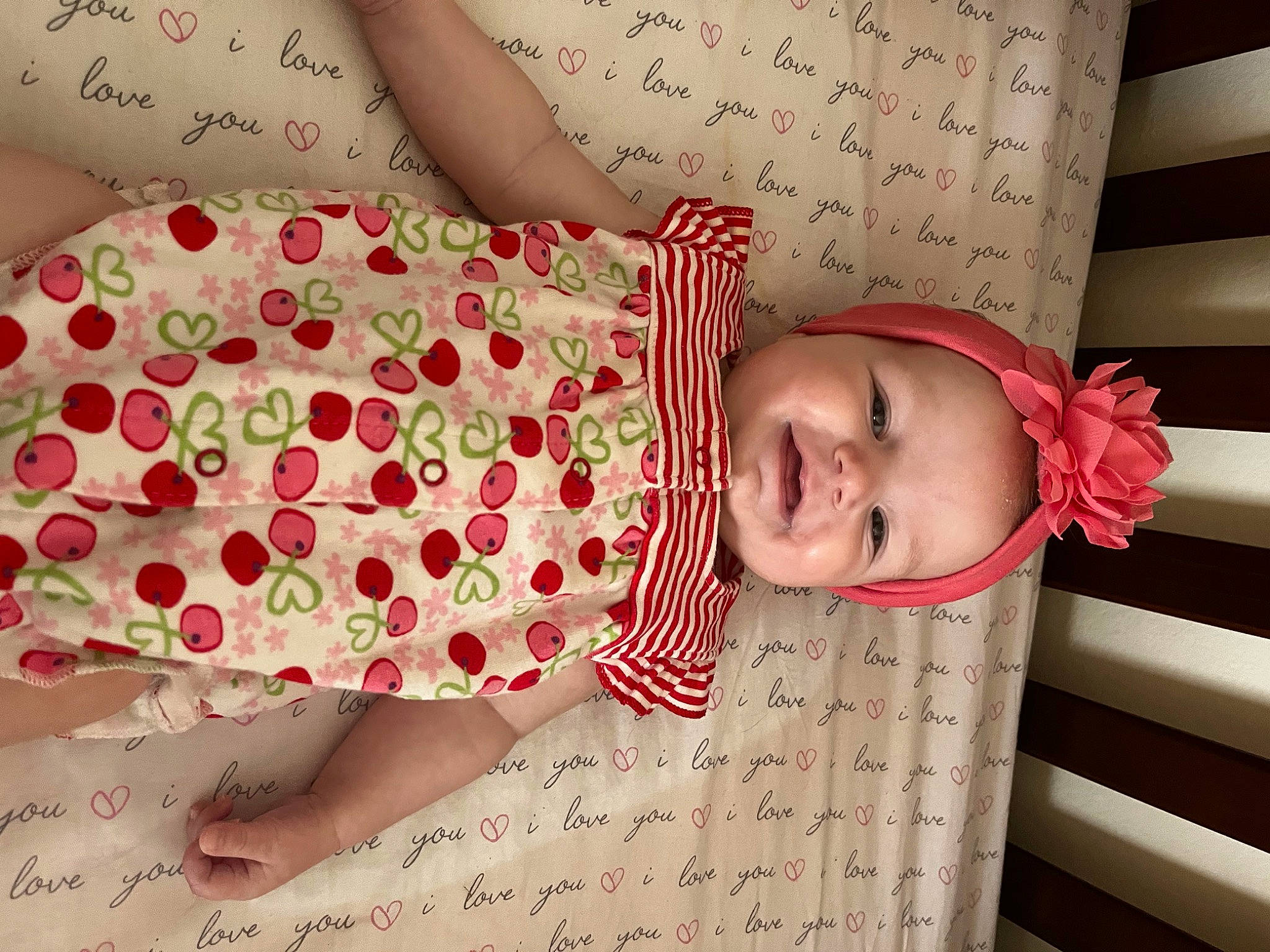 Daisy is registered to the contest to win money with this photo: arm, baby, baby_safety, baby_toddler_clothing, child, comfort, finger, flower, hand, happy, headwear, human_leg, nail, pattern, person, pink, plant, skin, sleeve, textile