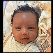 Lucas is registered to the contest to win money with this photo: baby, blanket, child, closeup, clothing, curly_hair, cute, expression, eyes, face, indoor, infant, mouth, newborn, nose, portrait, skin, soft, tag, texture