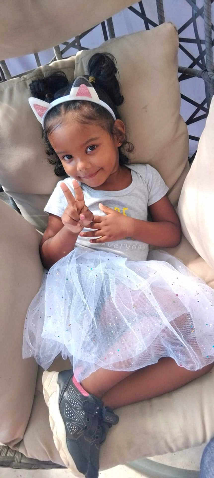 Indyra participe au concours pour gagner de l'argent avec cette photo : casual, cat_ears, chair, child, cushion, cute, fashion, girl, happy, headband, indoor, peace_sign, person, playful, portrait, sitting, skirt, smile, sneakers, tutu