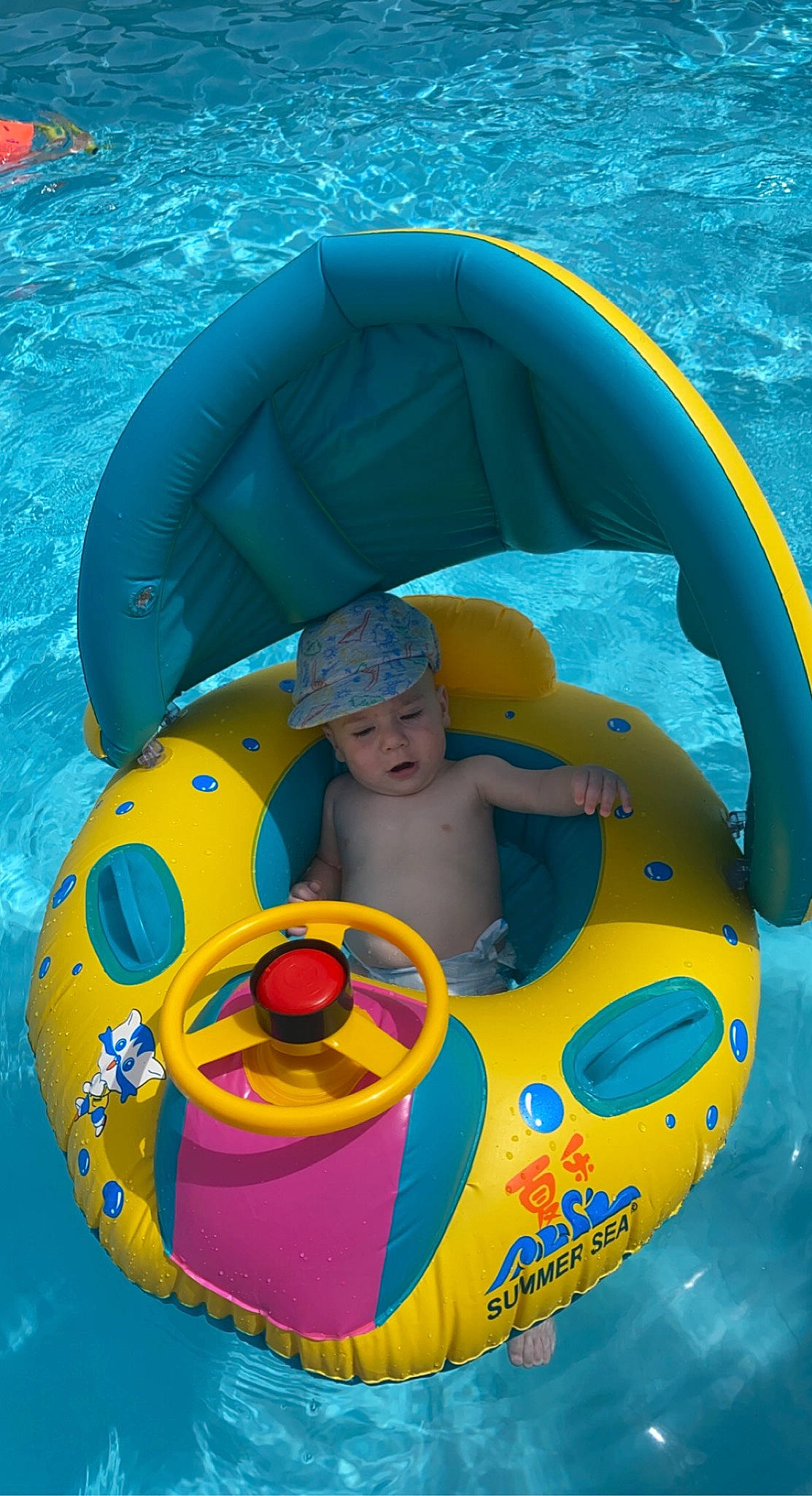 Jullian a rejoint le concours — aidez-le/la à gagner de superbes lots ! aqua, baby, baby_float, baby_products, baby_toddler_clothing, child, circle, fun, games, green, headwear, inflatable, leisure, nonbuilding_structure, outdoor_recreation, person, personal_protective_equipment, photograph, product, recreation