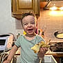toddler, child, smiling, happy, food, kitchen, cabinet, appliance, counter, light, indoor, person, short_sleeve_shirt, standing, cute, portrait, young_child, bread, meal, home