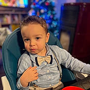 Timéo a rejoint le concours — aidez-le/la à gagner de superbes lots ! toddler, child, boy, high_chair, bow_tie, shirt, suspenders, indoor, christmas_tree, blurred_background, holiday, festive, table, red_bowl, portrait, cute, young_child, seated, face, expression