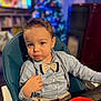 toddler, child, boy, high_chair, bow_tie, shirt, suspenders, indoor, christmas_tree, blurred_background, holiday, festive, table, red_bowl, portrait, cute, young_child, seated, face, expression