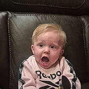 Harmony Reye Lane joined the competition — help win amazing prizes! apparel, baby, casual_clothing, child, cute, expression, face, hand, head, indoor, infant, leather_chair, person, pink_sweatshirt, reebok, remote_control, seated, sitting, surprised, young_child