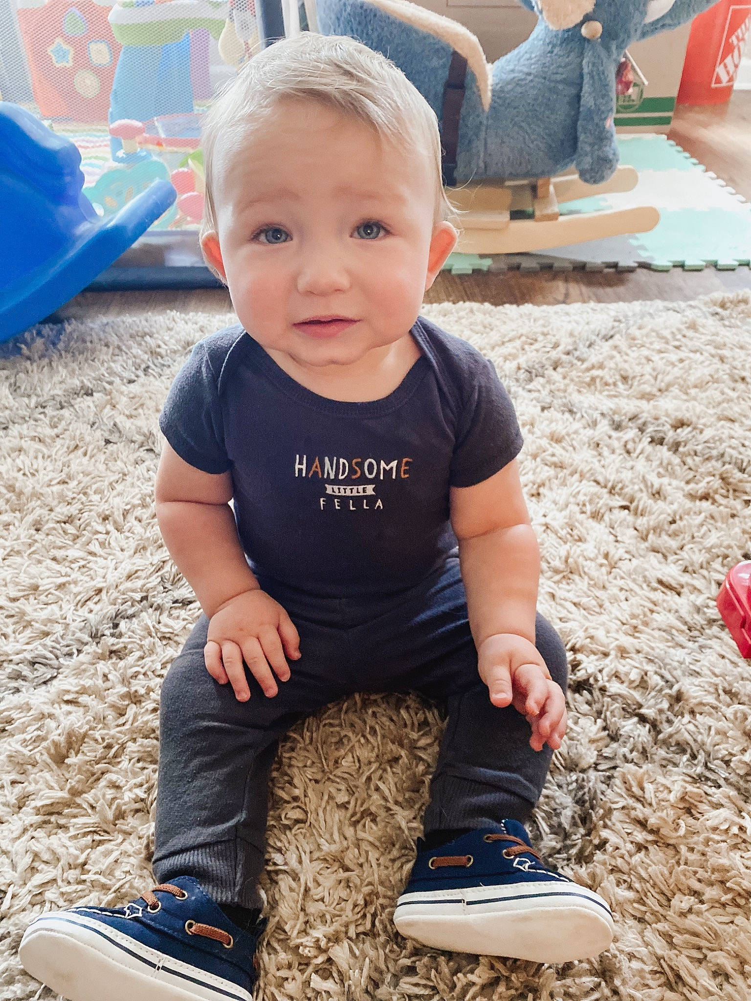 Xander is registered to the contest to win money with this photo: baby_toddler_clothing, blue, child, composite_material, cool, electric_blue, fun, grass, happy, leisure, person, photograph, recreation, shoe, sitting, sleeve, smile, sneakers, toddler, walking_shoe