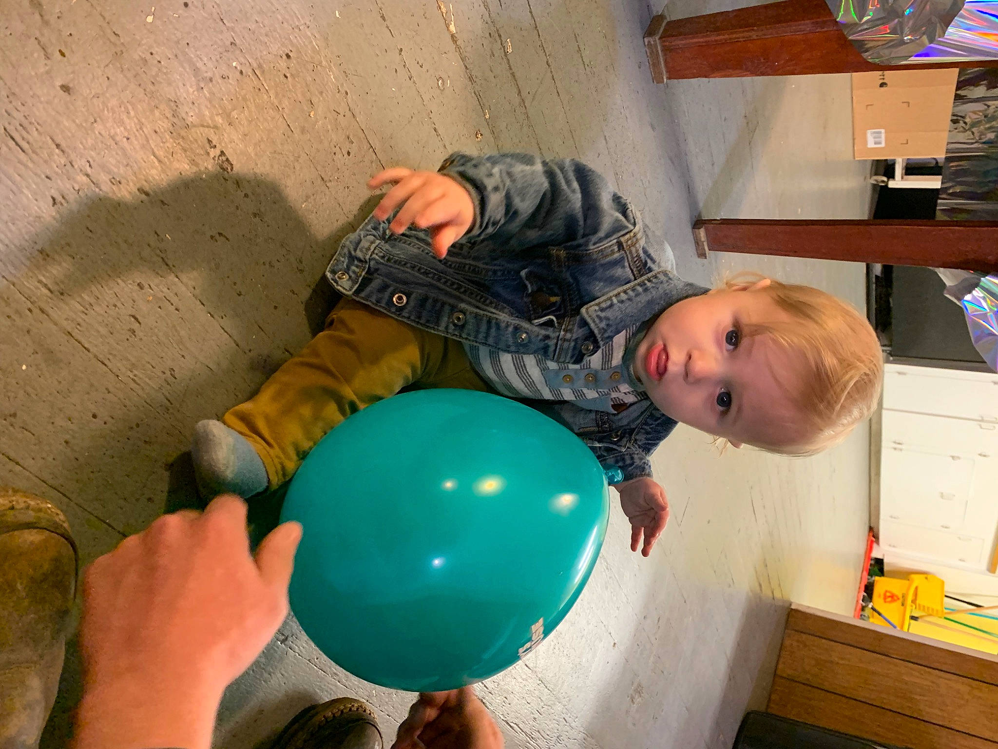 Byron is registered to the contest to win money with this photo: balloon, child, electric_blue, event, finger, fun, happy, leisure, party_supply, person, play, shelf, smile, space, t_shirt, toddler, wood, world