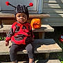 child, costume, ladybug, pumpkin, jackolantern, steps, outdoor, sunlight, black, red, hat, shoes, wood, person, fall, halloween, cute, expression, sitting, holiday