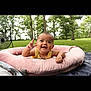 baby, infant, smiling, outdoor, greenery, trees, grass, pink_cushion, happy, child, person, nature, summer, playtime, cute, face, hand, park, relaxing, sunlight