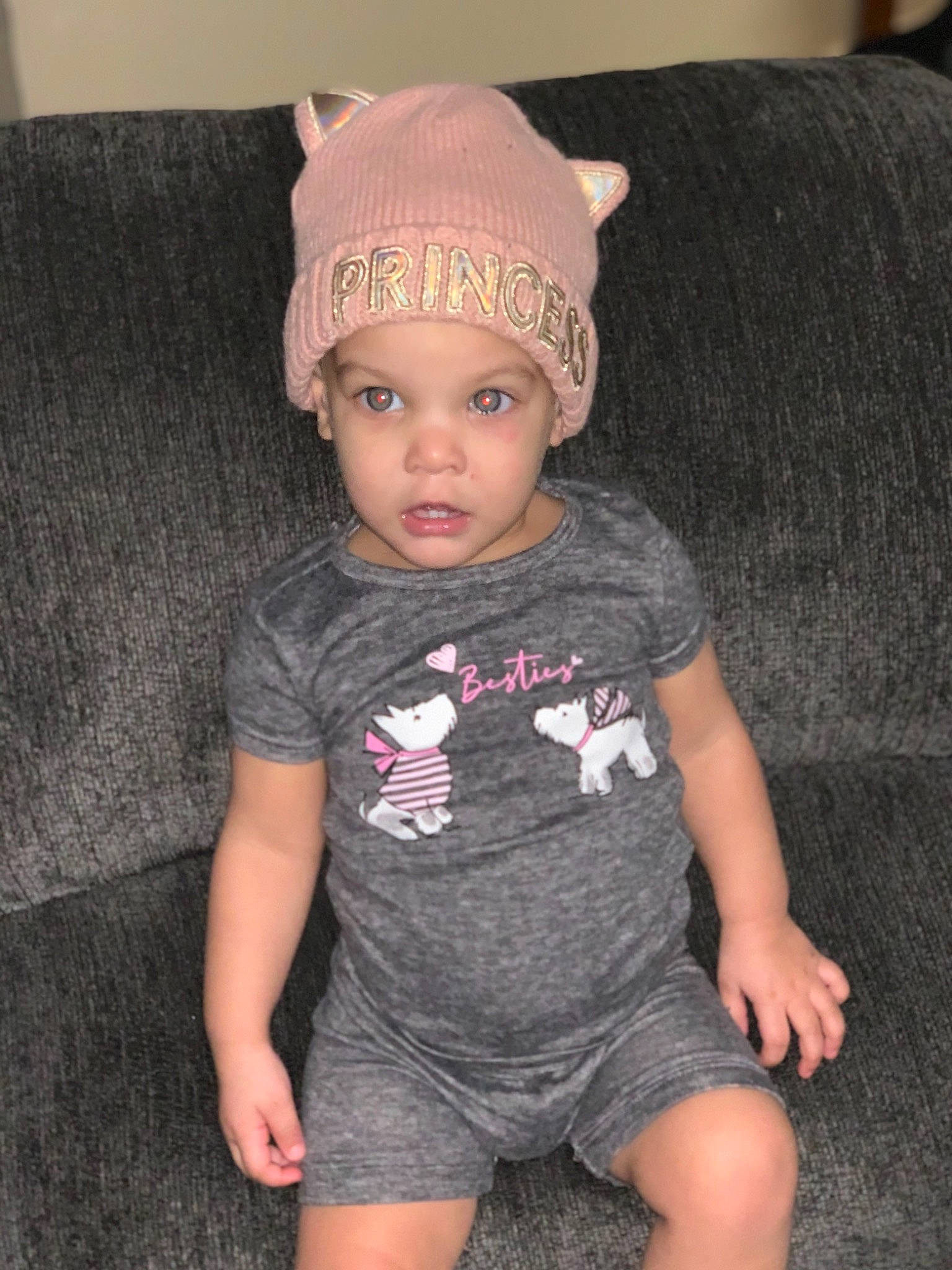 Alaia is registered to the contest to win money with this photo: baby, baby_toddler_clothing, beanie, bonnet, child_model, comfort, costume_accessory, couch, headband, headpiece, headwear, living_room, nightwear, person, wool