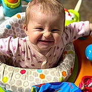 Ivy is registered to the contest to win money with this photo: baby, infant, child, smiling, happy, portrait, face, sitting, playmat, activity_center, baby_toys, colorful, indoors, pink_clothing, onesie, playtime, nursery, close_up, grinning, toy