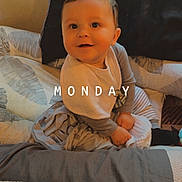 Arthur is registered to the contest to win money with this photo: baby, bed, bedding, bedroom, blanket, child, clothing, cozy, face, happy, home, indoor, infant, long_sleeves, monday, pillow, portrait, sitting, smiling, text_overlay
