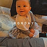 baby, bed, bedding, bedroom, blanket, child, clothing, cozy, face, happy, home, indoor, infant, long_sleeves, monday, pillow, portrait, sitting, smiling, text_overlay