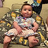 baby, child, infant, couch, cushion, animal_pattern, bunny, striped_pants, pink, gray, colorful, cute, smile, indoors, furniture, soft_toys, blanket, relaxed, portrait, person