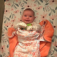 Valerica joined the competition — help win amazing prizes! baby, bed, blanket, child, cozy, cute, face, floral_pattern, happy, head, indoors, infant, lying_down, mittens, orange_blanket, person, portrait, sheet, smile, soft_texture