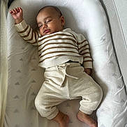 Ethan participe au concours pour gagner de l'argent avec cette photo : baby, sleeping, infant, striped_clothing, cozy, soft_bedding, peaceful, child, cute, relaxed, pajamas, white, cushion, indoors, young_child, resting, comfort, small_feet, raised_arm, portrait